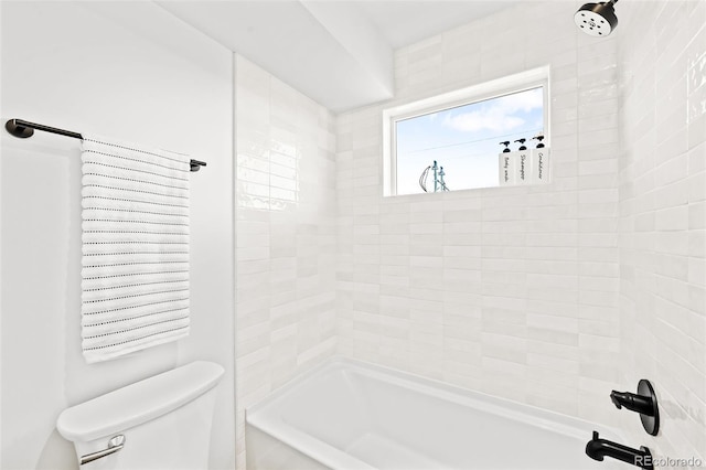 bathroom featuring toilet and tiled shower / bath