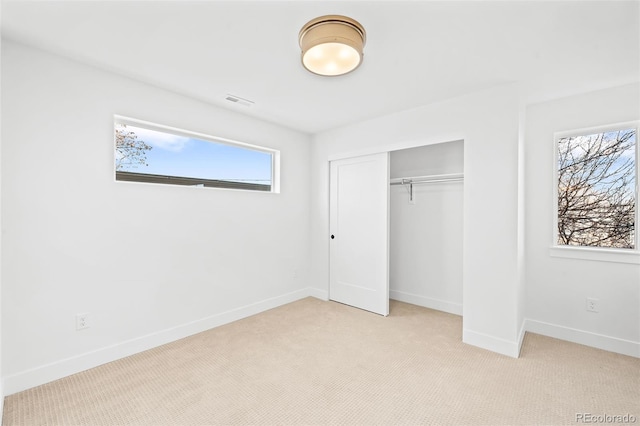 unfurnished bedroom with a closet and light carpet