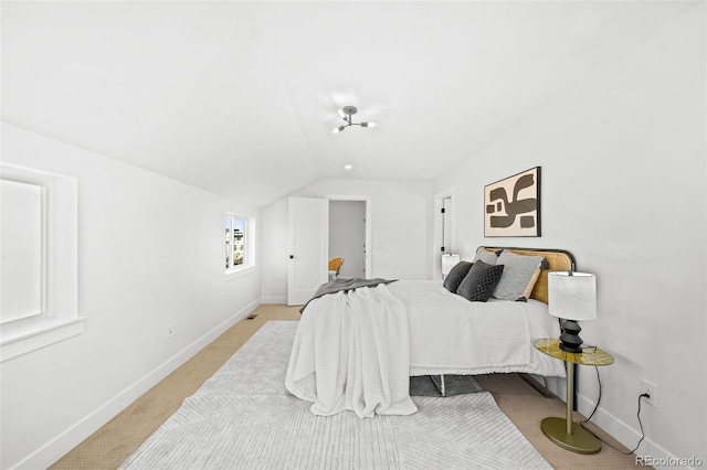 bedroom with light carpet and vaulted ceiling