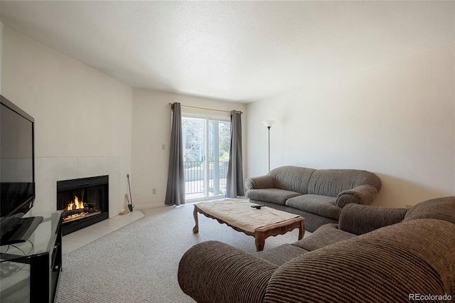 living room featuring a tiled fireplace and carpet floors