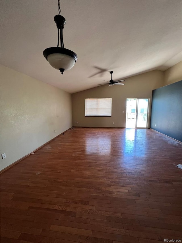 empty room with dark hardwood / wood-style floors, vaulted ceiling, and ceiling fan