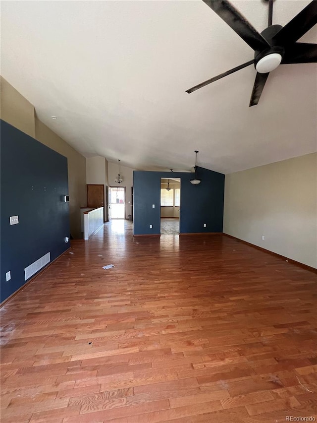 unfurnished living room with ceiling fan, light wood-type flooring, and lofted ceiling