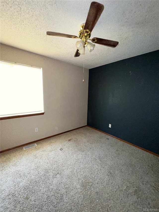 unfurnished room featuring carpet, ceiling fan, and a textured ceiling