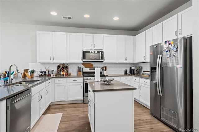 15503 W 65th Ave Unit C, Arvada, CO 80007 - kitchen featuring stainless steel appliances, backsplash, wood finished floors, white cabinetry, and recessed lighting