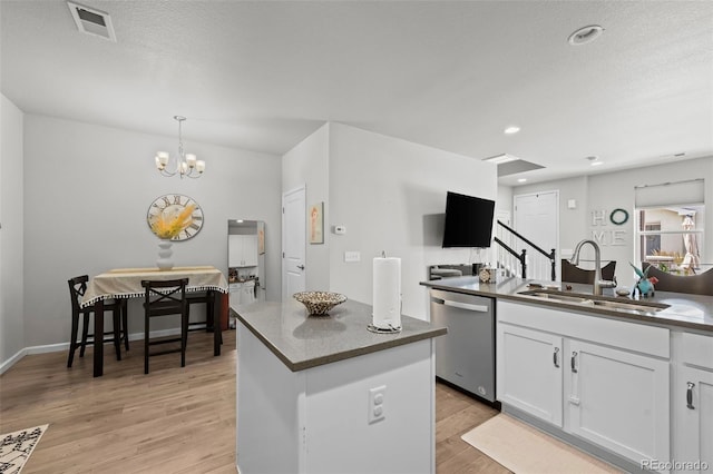 15503 W 65th Ave Unit C, Arvada, CO 80007 - kitchen featuring stainless steel dishwasher, white cabinets, light wood-style flooring, dark countertops, and a kitchen island