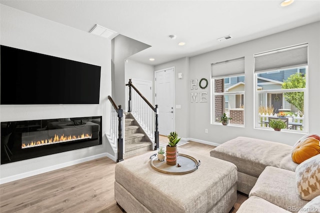15503 W 65th Ave Unit C, Arvada, CO 80007 - living area with wood finished floors, recessed lighting, a glass covered fireplace, and stairway