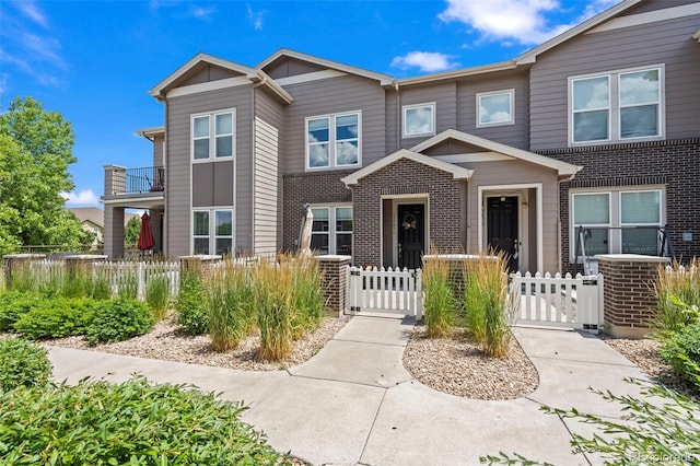 15503 W 65th Ave Unit C, Arvada, CO 80007 - view of property with a gate, a fenced front yard, and brick siding
