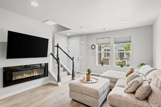 15503 W 65th Ave Unit C, Arvada, CO 80007 - living area featuring recessed lighting, light wood-style flooring, a glass covered fireplace, and stairway