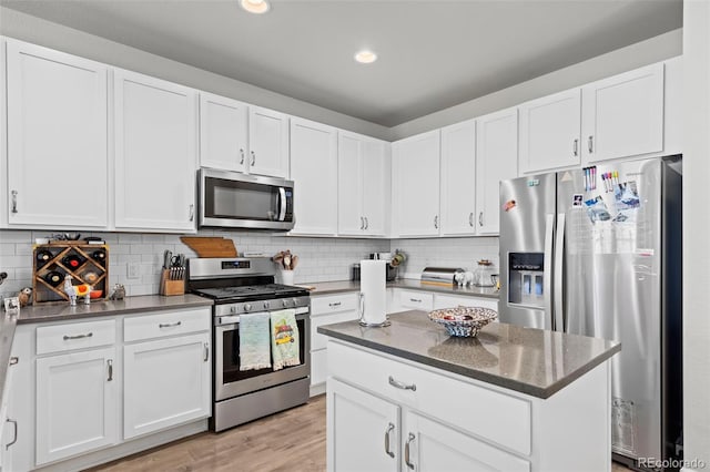 15503 W 65th Ave Unit C, Arvada, CO 80007 - kitchen with appliances with stainless steel finishes, white cabinetry, dark stone countertops, decorative backsplash, and recessed lighting