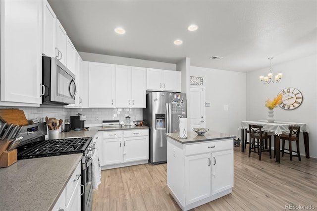 15503 W 65th Ave Unit C, Arvada, CO 80007 - kitchen featuring appliances with stainless steel finishes, backsplash, light wood-style floors, a kitchen island, and recessed lighting
