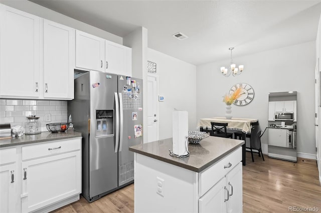 15503 W 65th Ave Unit C, Arvada, CO 80007 - kitchen featuring appliances with stainless steel finishes, tasteful backsplash, a chandelier, light wood-style floors, and white cabinets