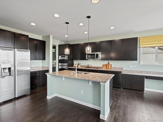 10730 Hillrose St, Parker, CO 80134 - kitchen featuring stainless steel appliances, a sink, a breakfast bar, dark wood-style flooring, and recessed lighting