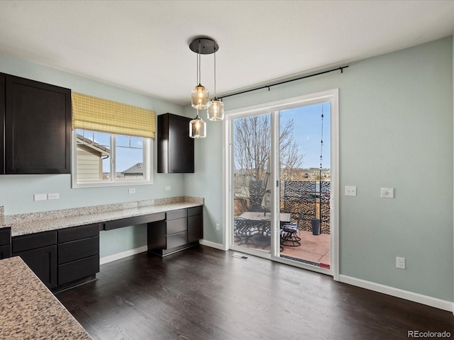 10730 Hillrose St, Parker, CO 80134 - kitchen with dark wood finished floors, baseboards, decorative light fixtures, and dark cabinets