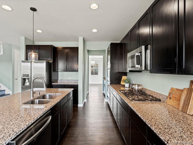 10730 Hillrose St, Parker, CO 80134 - kitchen with stainless steel appliances, a sink, dark wood-style flooring, light stone countertops, and recessed lighting