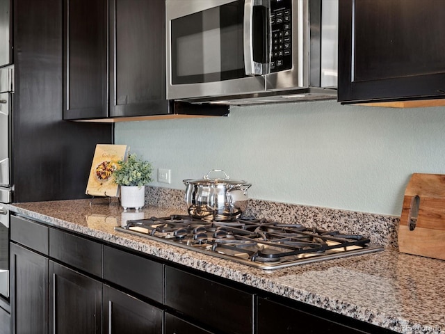 10730 Hillrose St, Parker, CO 80134 - kitchen with stainless steel appliances, dark cabinetry, and light stone countertops