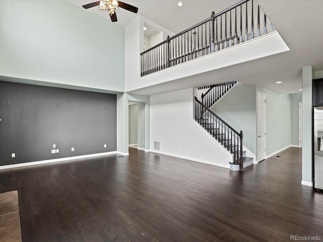 10730 Hillrose St, Parker, CO 80134 - unfurnished living room with a ceiling fan, stairs, wood finished floors, a high ceiling, and baseboards
