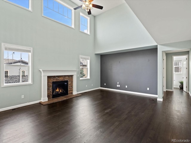 10730 Hillrose St, Parker, CO 80134 - unfurnished living room with ceiling fan, a high ceiling, wood finished floors, a fireplace, and baseboards