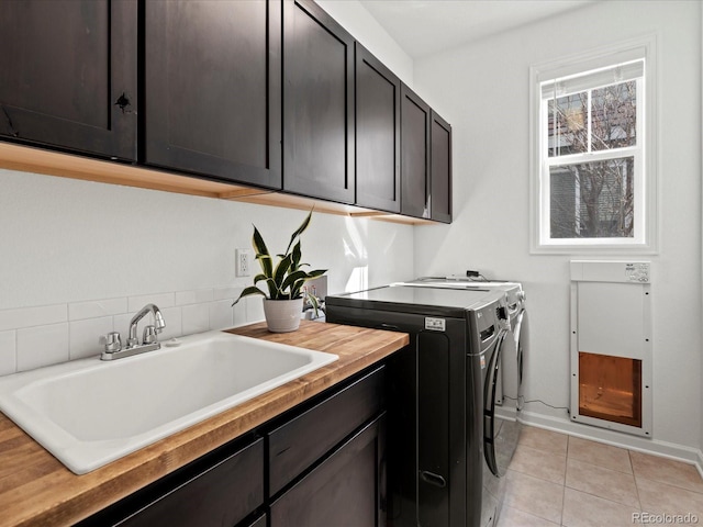 10730 Hillrose St, Parker, CO 80134 - washroom with separate washer and dryer, cabinet space, light tile patterned flooring, and baseboards