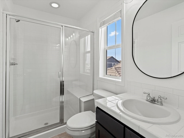 10730 Hillrose St, Parker, CO 80134 - bathroom featuring toilet, a stall shower, vanity, and tasteful backsplash