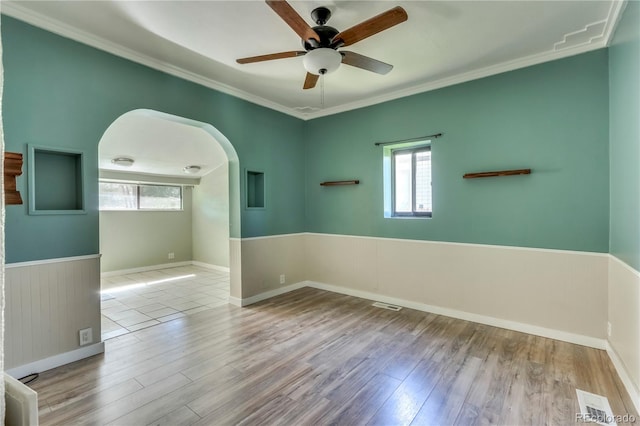 unfurnished room with light hardwood / wood-style flooring, a wealth of natural light, ceiling fan, and crown molding