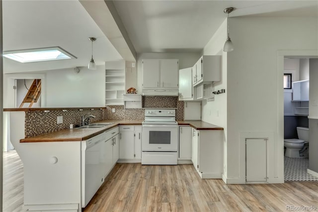 kitchen featuring white cabinets, white appliances, pendant lighting, a skylight, and sink