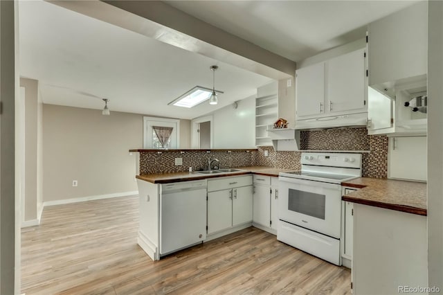 kitchen with white appliances, white cabinetry, sink, and kitchen peninsula