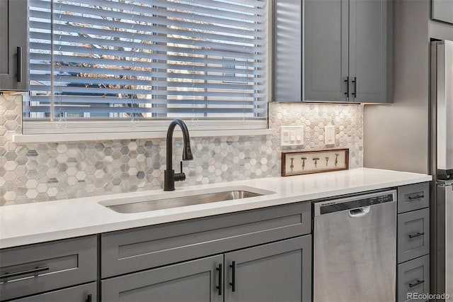 kitchen with stainless steel appliances, a healthy amount of sunlight, gray cabinets, and sink