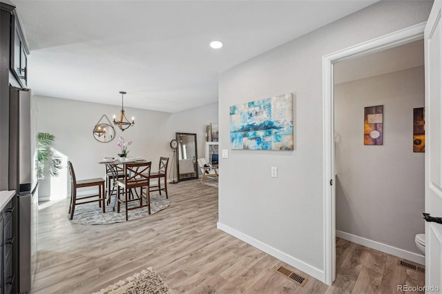 dining space featuring a chandelier and light hardwood / wood-style flooring