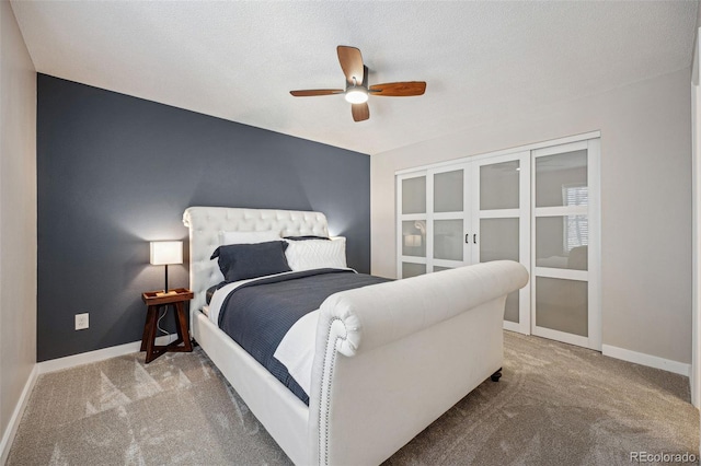 bedroom featuring light colored carpet, a textured ceiling, and ceiling fan