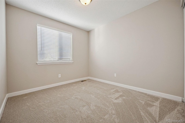 carpeted spare room featuring a textured ceiling