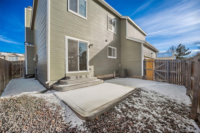 snow covered rear of property with a patio and central air condition unit