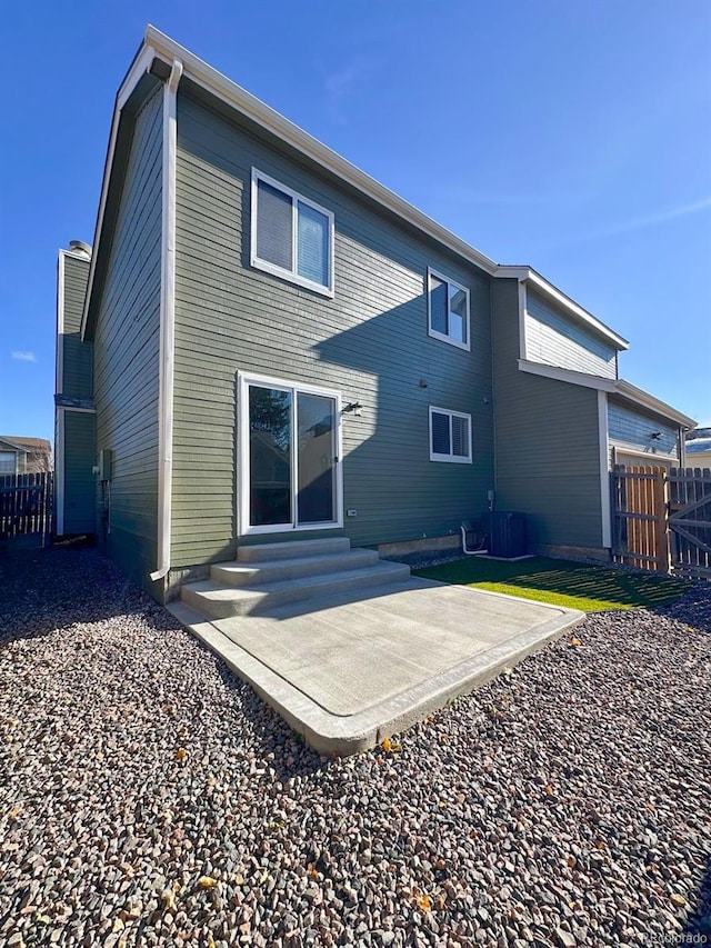 back of property with central AC and a patio