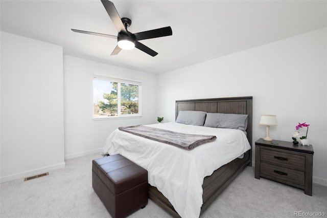 bedroom featuring light carpet, baseboards, visible vents, and a ceiling fan