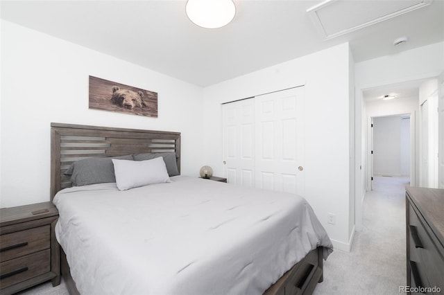 bedroom with attic access, a closet, and light carpet