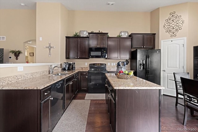 kitchen with dark brown cabinetry, a sink, black appliances, and dark wood-type flooring