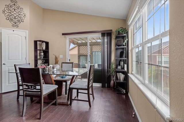 dining room with baseboards, dark wood-style floors, and lofted ceiling