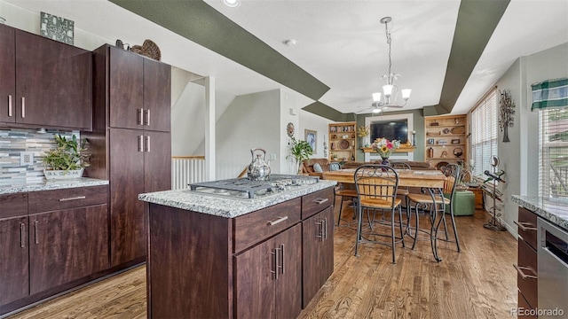kitchen with pendant lighting, a notable chandelier, light wood-type flooring, open floor plan, and stainless steel appliances