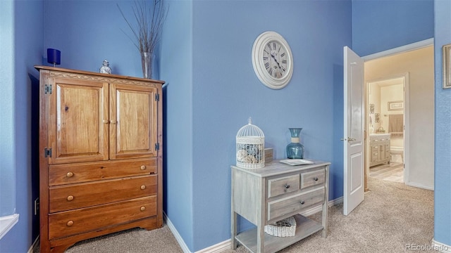 interior space with baseboards and light carpet