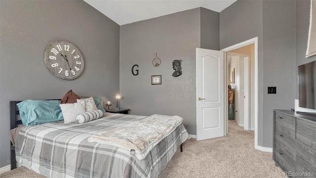 bedroom with baseboards and light carpet