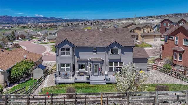 rear view of house featuring fence private yard, a deck with mountain view, and a residential view