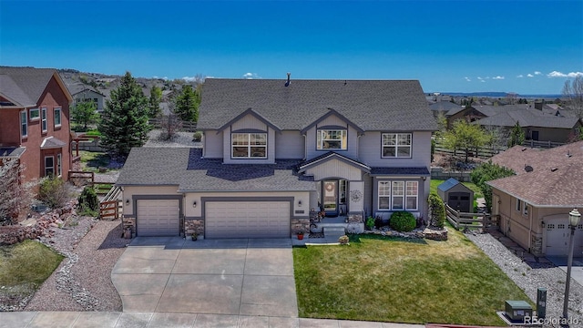 view of front of property with a shingled roof, fence, a front yard, and concrete driveway