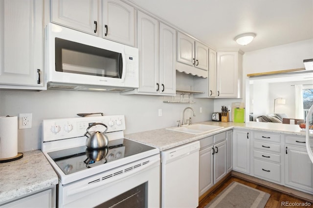 kitchen featuring white cabinetry, sink, white appliances, and dark hardwood / wood-style flooring