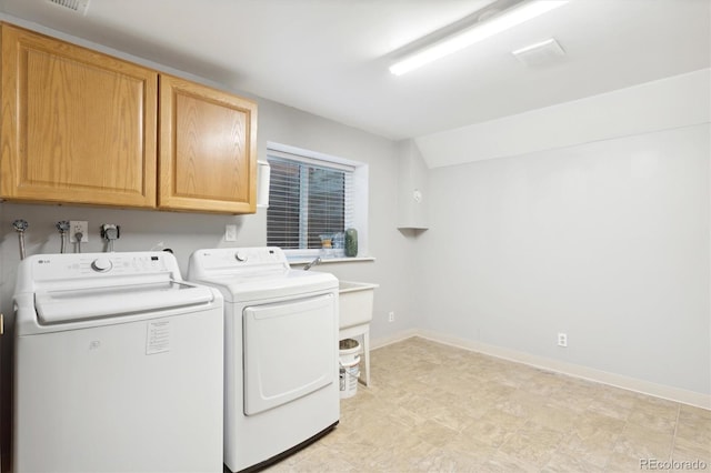 clothes washing area with cabinets and washer and dryer