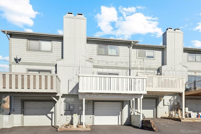 back of property with a garage and a balcony