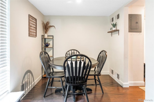 dining area with electric panel and dark hardwood / wood-style floors