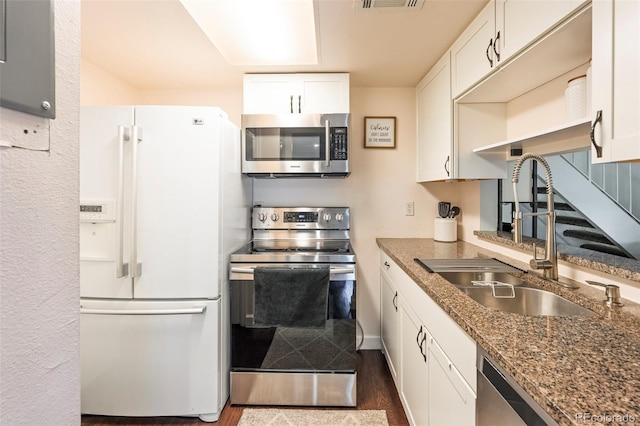 kitchen featuring white cabinets, stone counters, appliances with stainless steel finishes, sink, and dark hardwood / wood-style floors