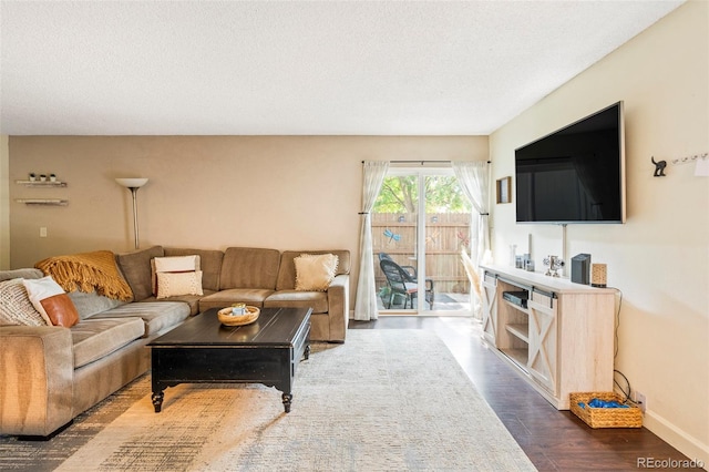 living room with a textured ceiling and dark hardwood / wood-style floors