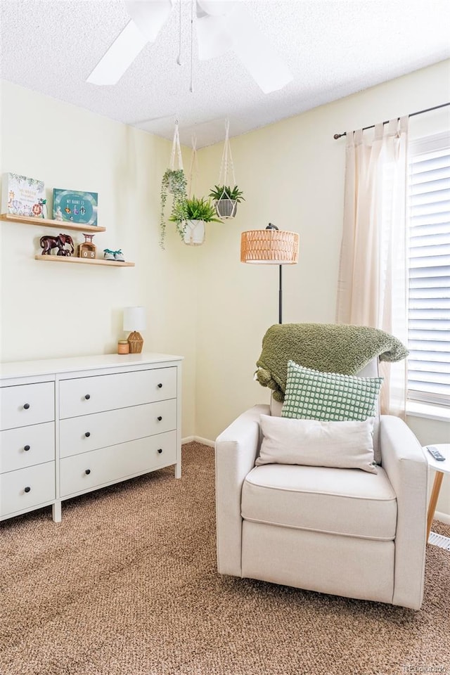 sitting room featuring a textured ceiling, ceiling fan, and carpet