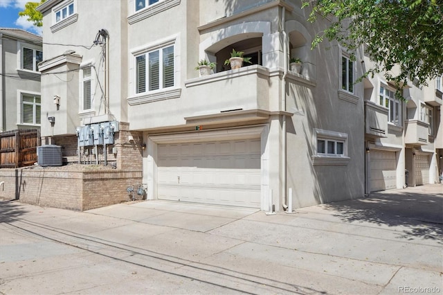 335 Josephine St Unit D, Denver, CO 80206 - view of front of house with driveway, an attached garage, stucco siding, and a balcony