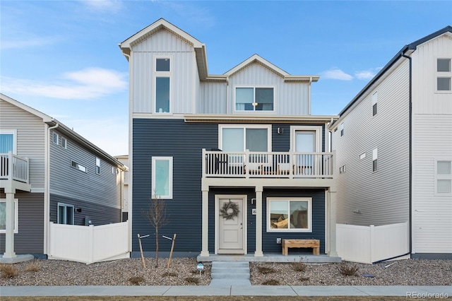 view of front of property featuring a balcony, fence, and board and batten siding